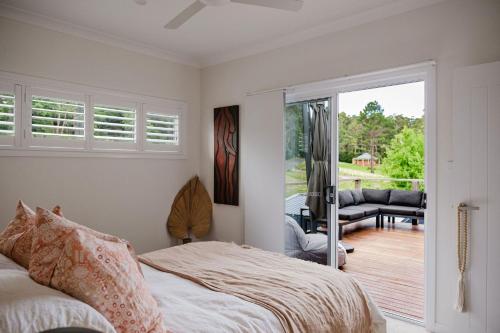 Un dormitorio con una cama y una puerta corrediza de vidrio. en The Lake Escape, en Yatte Yattah