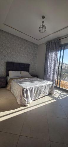 um quarto com uma cama e uma janela grande em luxury apartment DT2 em Mohammedia