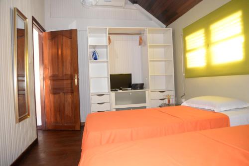 a bedroom with two beds and a television in it at Maison de vacance 2 Chambres à 200m de la plage in Sainte-Anne
