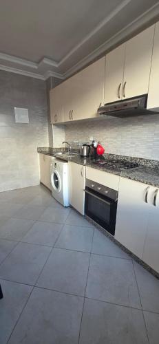 uma cozinha com um fogão e uma máquina de lavar roupa em luxury apartment DT2 em Mohammedia