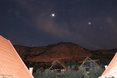 a view of a mountain at night with the moon at Dana luxury huts in Dana