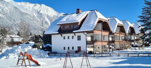 a house with a snow covered roof in the snow at Alpenblick Apartment in Hermagor