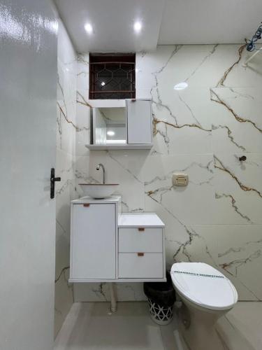 a white bathroom with a sink and a toilet at Maxi Palace hotel in Capitão Leônidas Marques