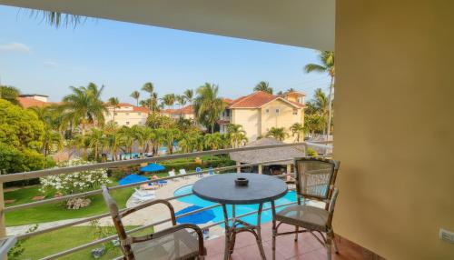 a balcony with a table and chairs and a view of a pool at Ocean Dream Studios Cabarete in Cabarete