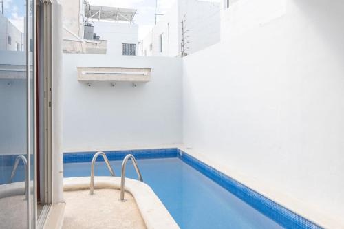 a swimming pool in a white and blue room at Casa Medina in Chetumal