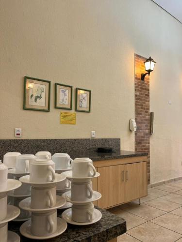 a group of white dishes on a table in a room at Hotel Portal do Eden in Sorocaba