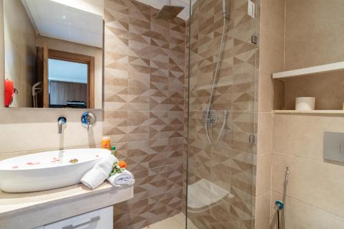 a bathroom with a sink and a shower at Appartement Moderne Poolside Gueliz centre Sun PS4 & Wi-Fi in Marrakesh