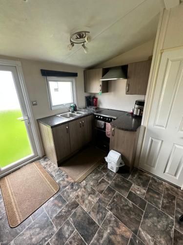 a small kitchen with a sink and a window at 16 orchid meadows in Ashington