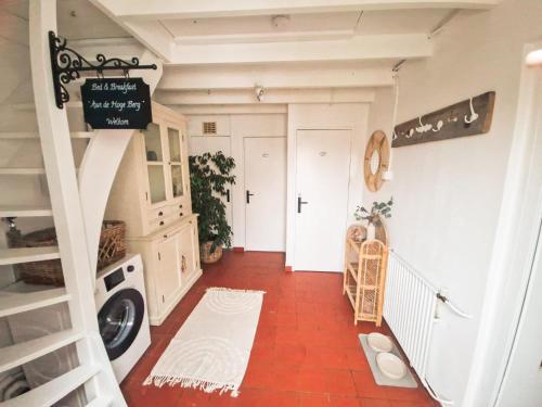 a hallway with a staircase and a laundry room at B&B Aan de Hoge Berg in Den Burg