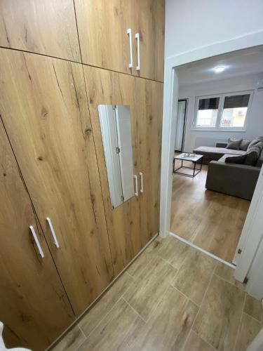 a room with wooden cabinets and a living room at Vasiljević Apartman Koviljača in Banja Koviljača