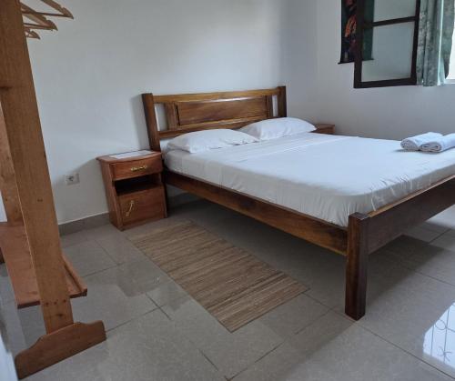 Un dormitorio con dos camas y una mesita de noche. en Passadeira Garden, en São Tomé