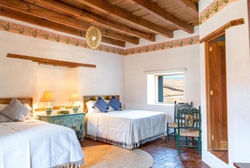 Un dormitorio con dos camas y una ventana. en Batucada Hotel Boutique, en Valle de Bravo