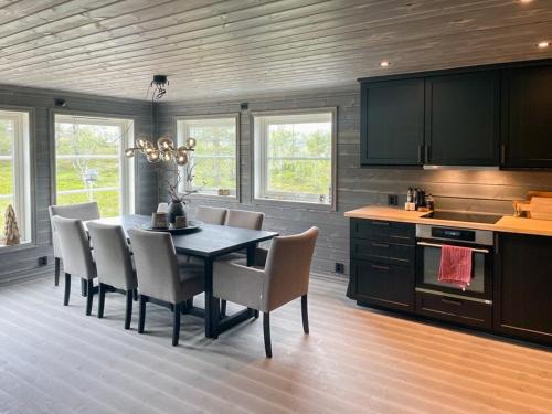 a kitchen with a dining room table and chairs at Modern Cabin By Hardangervidda in Garden