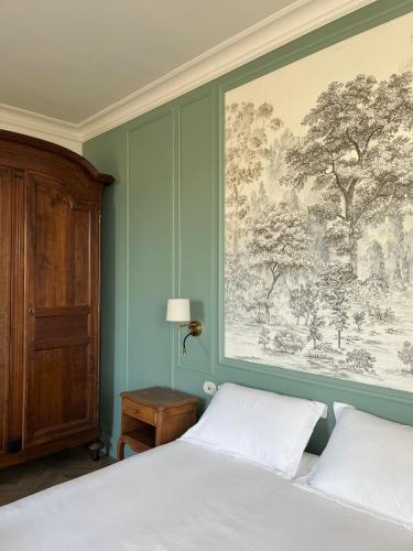 a bedroom with a bed and a large painting on the wall at Manoir de Salleviale in Conques-en-Rouergue