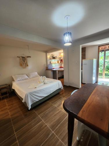 a bedroom with a bed and a table in it at Loft Iemanjá in Itacaré