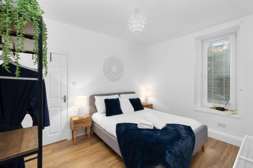 een witte slaapkamer met een bed en een raam bij 92 High Street in Carnoustie