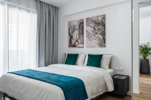 a bedroom with a large bed with a blue blanket at 26 Suites in Limassol