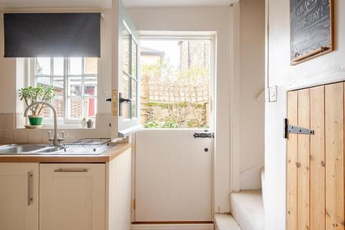 a kitchen with a sink and a window at Charming Georgian flint cottage in Bury Saint Edmunds