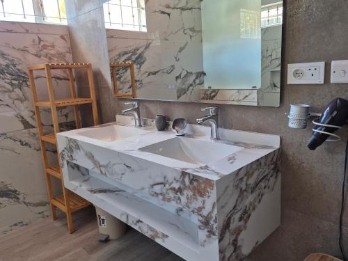 bagno con lavabo in marmo e specchio di Jolie Villa Santa avec piscine a Pointe-aux-Piments