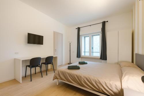 a bedroom with a bed and two chairs and a desk at Luminosa stanza 4 bagno privato vicino Stazione in Padova