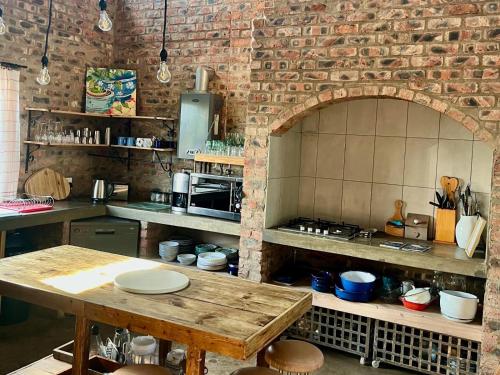 a kitchen with a table and a brick wall at De Krantz 6 Estate in Clarens