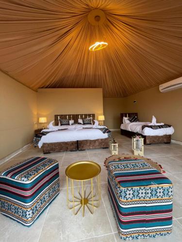 a hotel room with two beds and a table at Spirit of the Badia camp in Disah