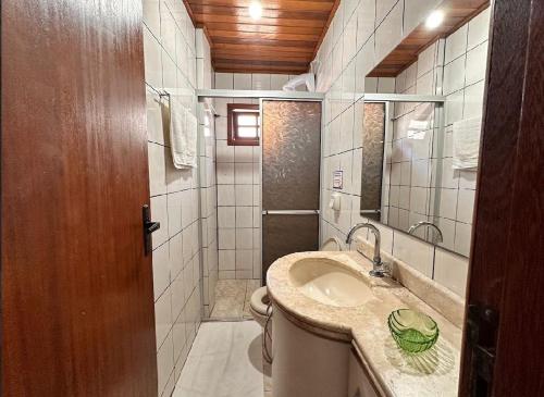 a bathroom with a sink and a toilet at Pousada Residencial dos Corais in Bombinhas