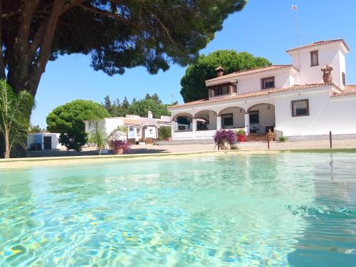 una casa con una piscina de agua frente a ella en CÁDIZ -TIPI en Chiclana de la frontera, España, en Chiclana de la Frontera