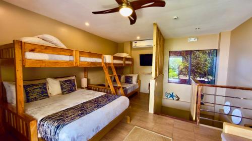 sypialnia z 2 łóżkami piętrowymi i wentylatorem sufitowym w obiekcie Southseas Beach Resort and Dive Center w mieście Santander