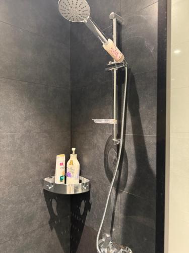 a shower with a shower head in a bathroom at Beautiful studio at aljada community in Sharjah