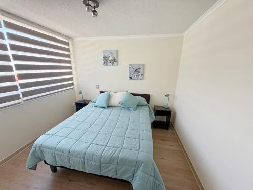 Un dormitorio con una cama y una ventana en Jardines del Pacífico IV, en La Serena