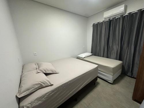 Un dormitorio con dos camas y una ventana. en Casa vaga 2 carros ou caminhonete, 2 quartos, espaçosa, completa para 8 pessoas, en Sinop