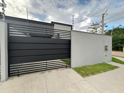 una cerca en blanco y negro frente a una casa en Casa vaga 2 carros ou caminhonete, 2 quartos, espaçosa, completa para 8 pessoas, en Sinop