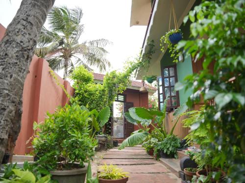 a walkway in front of a house with plants at Summer Beach House in Alleppey
