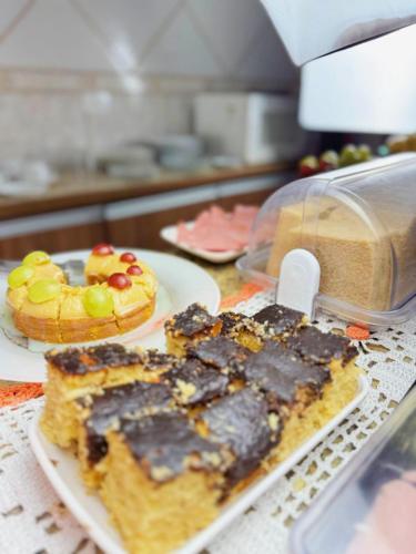 una mesa con un plato de comida y un pastel en Hostel Anprado #12, en Guarulhos