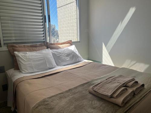 Beautiful apartment in Vila da Serra في نوفا ليما: سرير فيه فوطة ملقاة فوقه