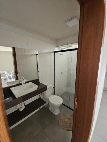 a bathroom with a toilet and a sink at Loft do Valle II in Sorriso