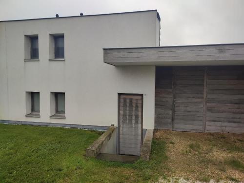 a white house with a door in front of it at Zanderover in Koksijde
