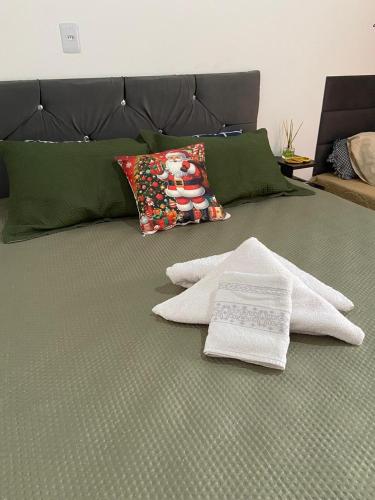 łóżko z 2 ręcznikami i poduszką w obiekcie Casa aconchegante e privativa w Foz do Iguaçu
