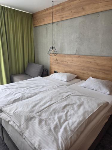 a bedroom with two white beds and a pendant at Czarna Perła Apartamenty Czarna Góra 512 in Sienna