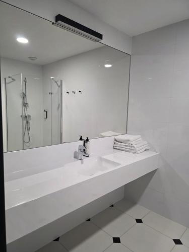 a white bathroom with a sink and a mirror at Czarna Perła Apartamenty Czarna Góra 512 in Sienna