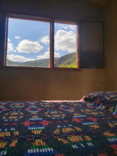 1 dormitorio con cama y ventana con manta en Pie de Sierra, en Los Hornillos