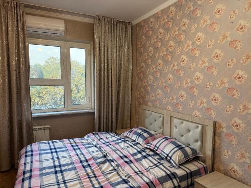 a bedroom with a bed and a window at Large Appartment & Central Place in Tashkent