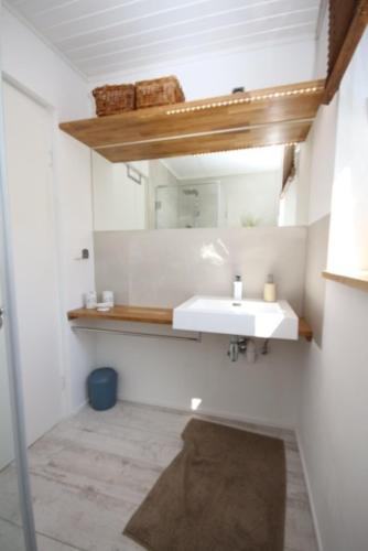a bathroom with a sink and a mirror at Ferienhaus Düne in Rowy