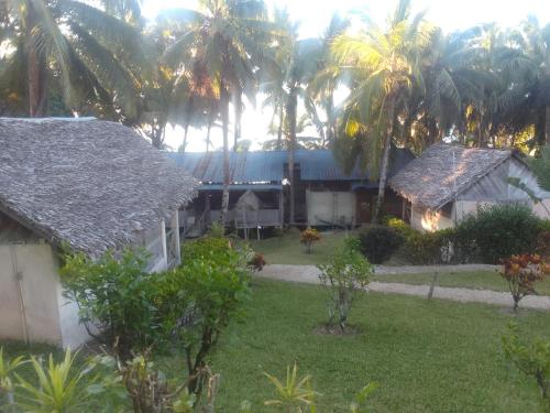 een uitzicht op een huis met palmbomen op de achtergrond bij Antafondro Lodge in Sainte Marie