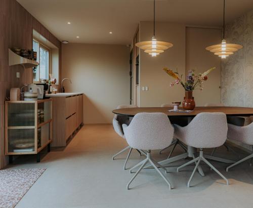 Una cocina con una mesa y sillas en una habitación. en Design Lodge - It Sluske New 2025, en Raerd