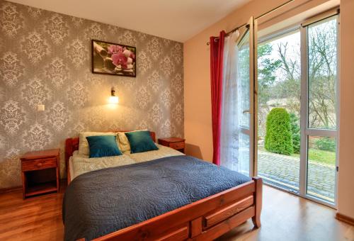 Un dormitorio con una cama y una ventana grande. en Słoneczny Brzeg Polańczyk-Dom na wyłączność, en Myczków
