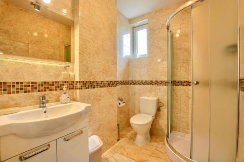 Un baño con lavabo, inodoro y ducha. en Słoneczny Brzeg Polańczyk-Dom na wyłączność, en Myczków