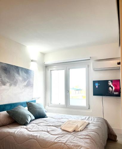 a bedroom with a large bed with a window at Urban House in Nuoro