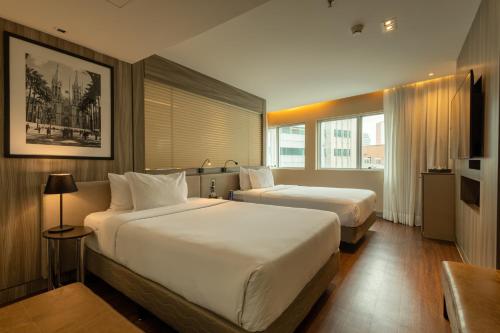 a hotel room with two beds and a window at Radisson Vila Olimpia Sao Paulo in São Paulo